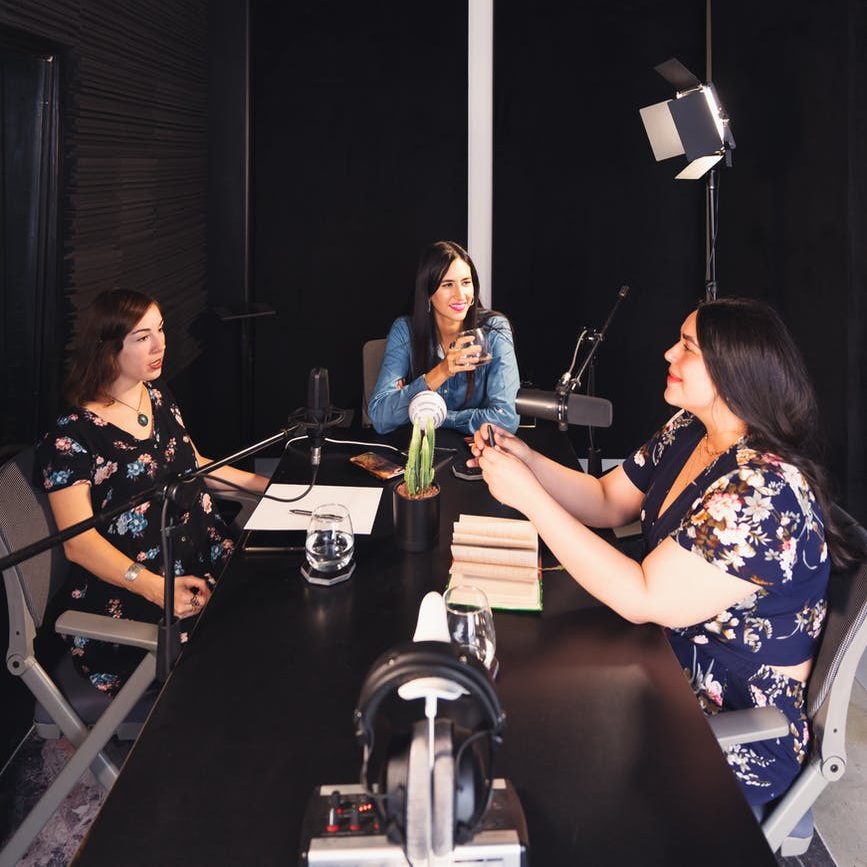 women sitting at the table podcasting